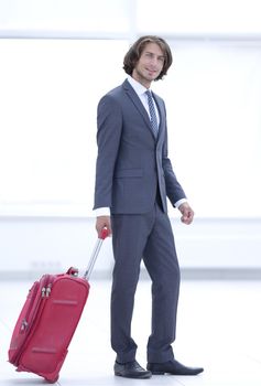 young businessman with travel suitcase .isolated