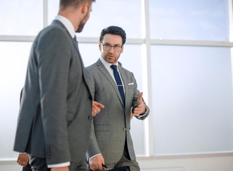 Busy businesspeople in office building, two businessmen walking along hallway, full-length window city view at background, running in hurry, business rush in lobby, working atmosphere,