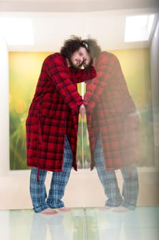 portrait of young man in bathrobe enjoying free time at home