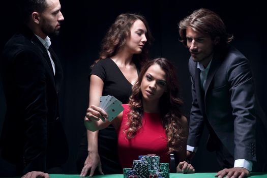 Pretty young woman with support group gambling on green table