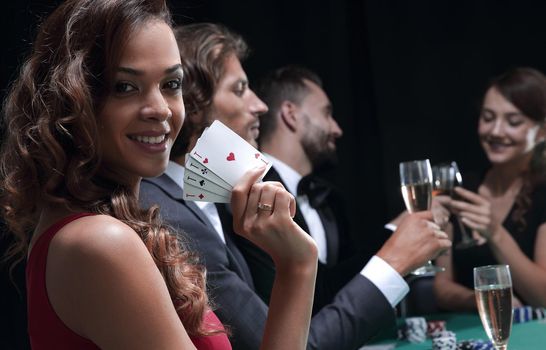 Smiling woman looking up from poker game in casino