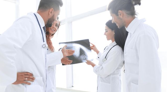 closeup of a group of doctors discussing an x-ray of the patient after surgery