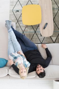 top view of Young couple on the sofa watching television together at home