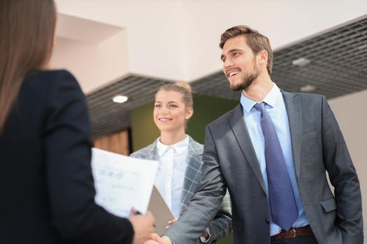 Business partners handshaking over business objects on workplace