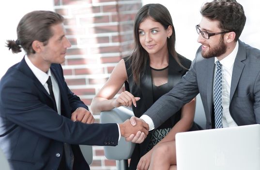 handshake business partners,sitting on the sofa in the office lobby