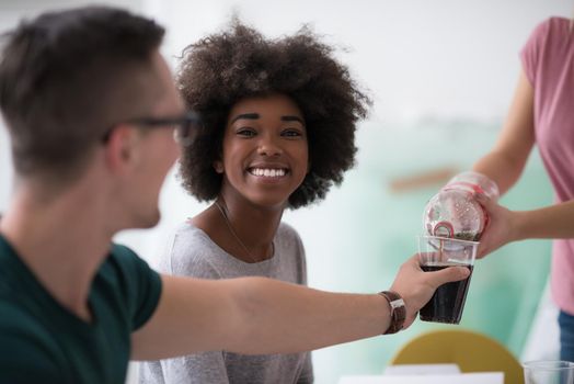 multiethnic group of young people have a lunch break after moving to a new home