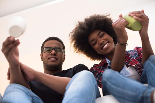 Happy young African American couple having break during moving to new house