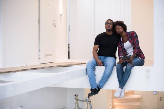 Happy young African American couple having break during moving to new house