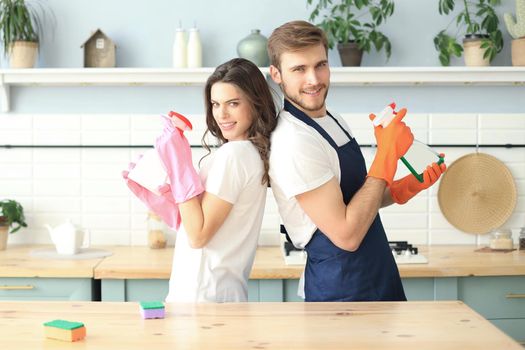 Young happy couple is having fun while doing cleaning at home