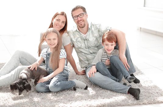 happy family sitting on the carpet in a new apartment.photo with copy space