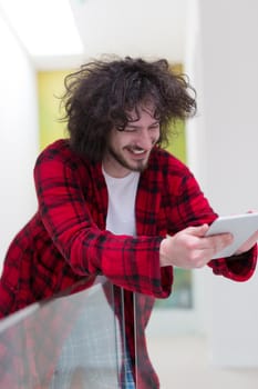 young freelancer in bathrobe working from home using tablet computer