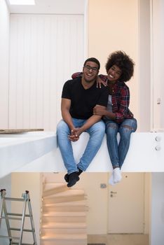 Happy young African American couple having break during moving to new house