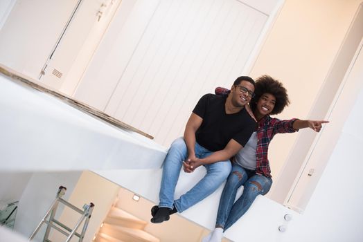 Happy young African American couple having break during moving to new house