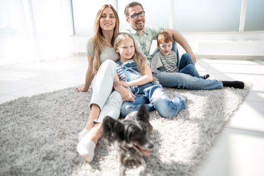 portrait of a happy family sitting on the living room floor.photo with copy space