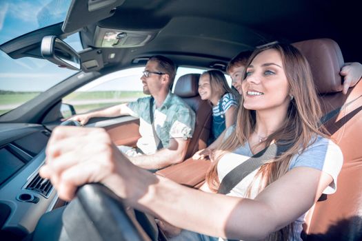 happy mom driving a family car .the concept of freedom and travel