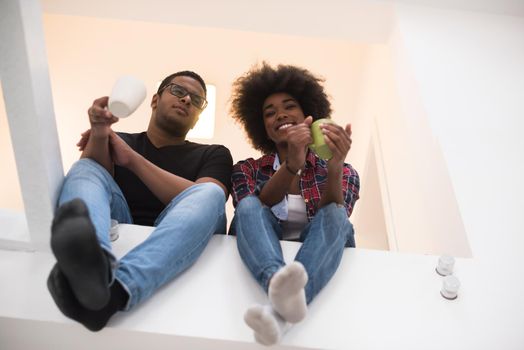 Happy young African American couple having break during moving to new house