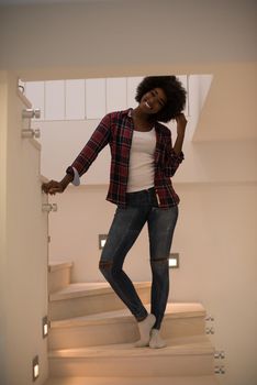 portrait of a beautiful young African American woman standing on the stairs in her luxurious home