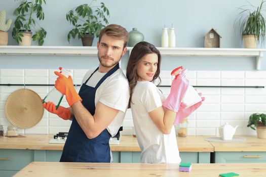 Young happy couple is having fun while doing cleaning at home