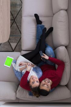 top view of Young couple on the sofa watching television together at home