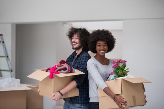 Happy young multiethnic couple unpacking or packing boxes and moving into a new home