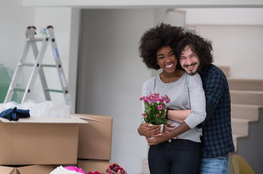 Happy young multiethnic couple unpacking or packing boxes and moving into a new home