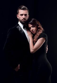 Portrait of young couple in love posing at studio dressed in classic clothes