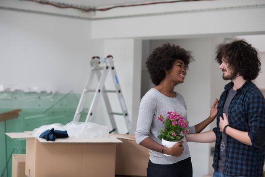 Happy young multiethnic couple unpacking or packing boxes and moving into a new home