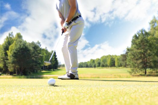 Golf approach shot with iron from fairway at sunny day