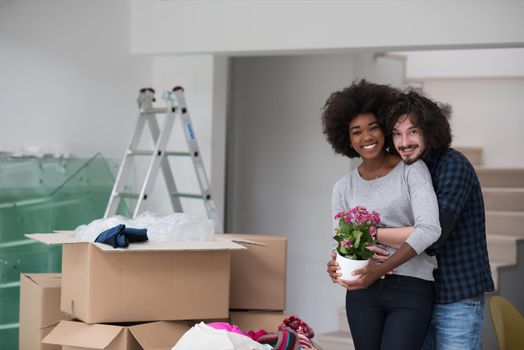 Happy young multiethnic couple unpacking or packing boxes and moving into a new home