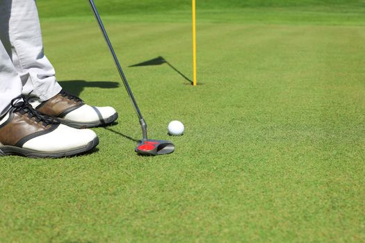 Golf approach shot with iron from fairway at sunny day