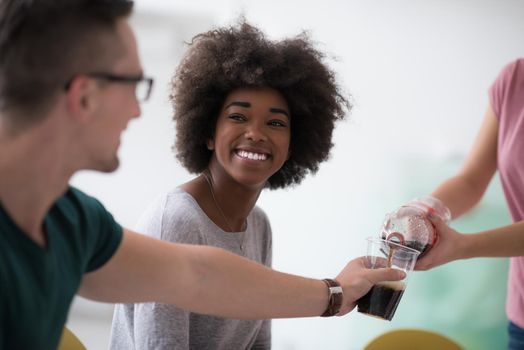 multiethnic group of young people have a lunch break after moving to a new home