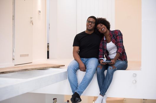 Happy young African American couple having break during moving to new house