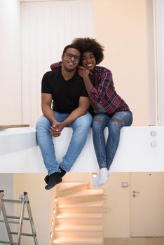 Happy young African American couple having break during moving to new house