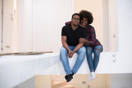 Happy young African American couple having break during moving to new house