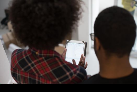Rear view of young african american couple using tablet at home