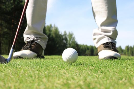 Golf approach shot with iron from fairway at sunny day