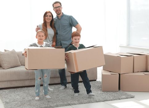 parents with their children moves the boxes to a new apartment.photo with copy space