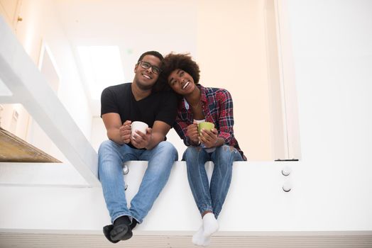 Happy young African American couple having break during moving to new house