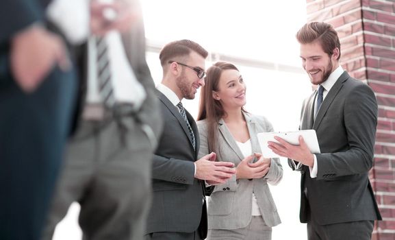 Smiling young businessman enjoying a positive conversation with a business partner in a modern space with large windows