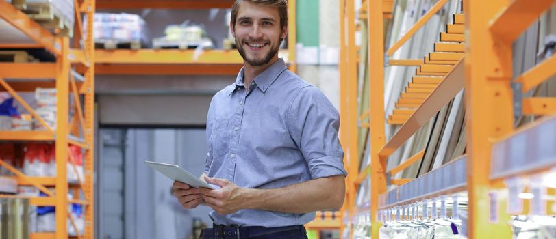 portrait of a smiling young warehouse worker working in a cash and carry wholesale store