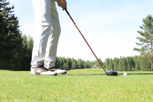 Golf approach shot with iron from fairway at sunny day