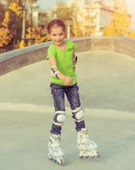 Cute little girl on roller skates at a park