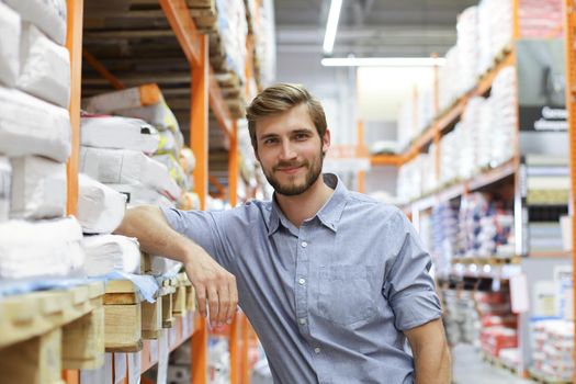 portrait of a smiling young warehouse worker working in a cash and carry wholesale store