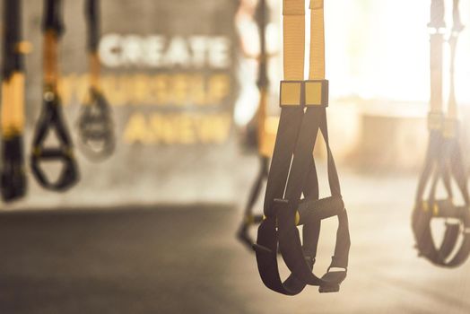 Fitness trx straps inside of a gym, functional training equipment and sport accessories. Active lifestyle, fitness and training concept