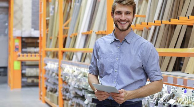 portrait of a smiling young warehouse worker working in a cash and carry wholesale store