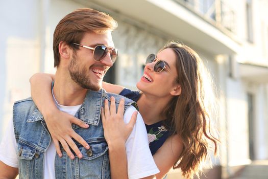 Beautiful young couple in love walking outdoors at the city street, hugging