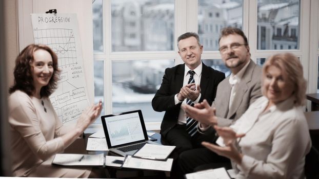 portrait of group of business people applauding speaker,sitting in the office