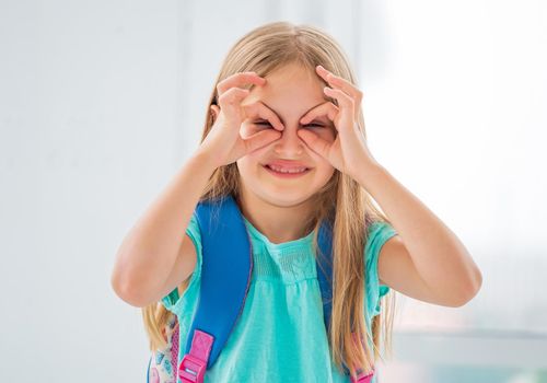 Funny looking little girl making fantastic masks and gestures with her hands