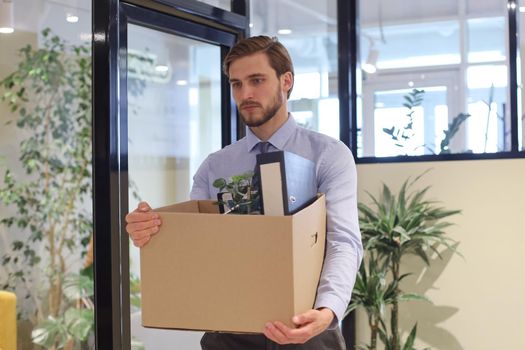 Dismissed worker going from the office with his office supplies