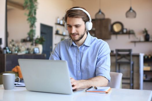 Confident man wearing headset speaking and watching business webinar training, listening to lecture